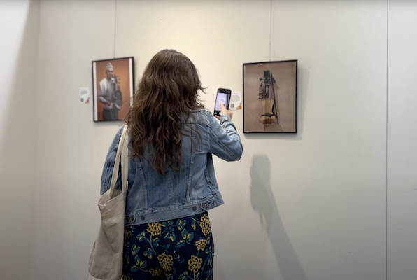 Sounds of South Asia exhibit on display, student taking picture 