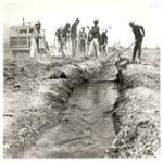 Evacuees working an irrigation ditch